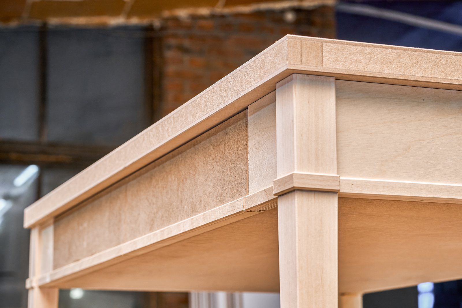 Close-up of a wood writing desk being finished in a joinery workshop