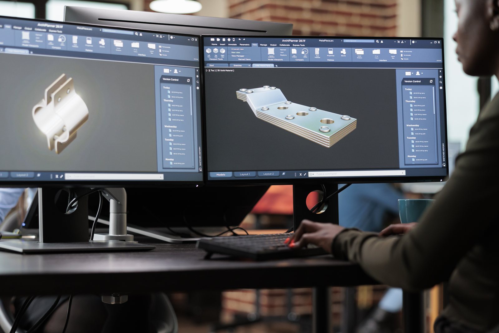 Dual monitors showing 3D CAD models of machined parts in a modelling application
