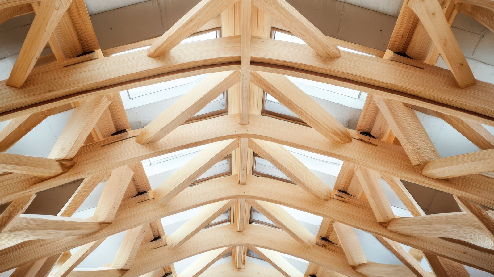 Intricate wooden architectural framework of arches and joinery inside a building