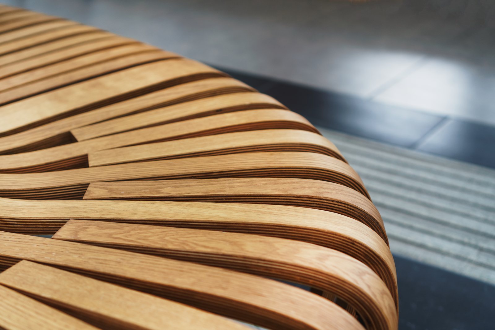 Close-up of a laminated curved wood bench formed from layered strips
