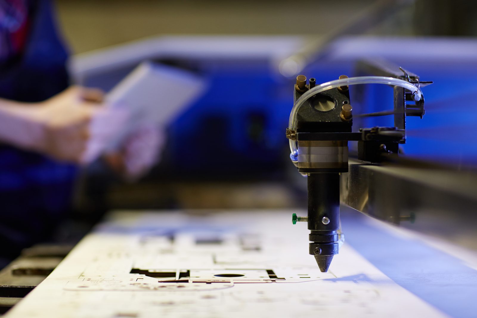 Close-up of a laser-cutting machine head cutting a panel on the production floor